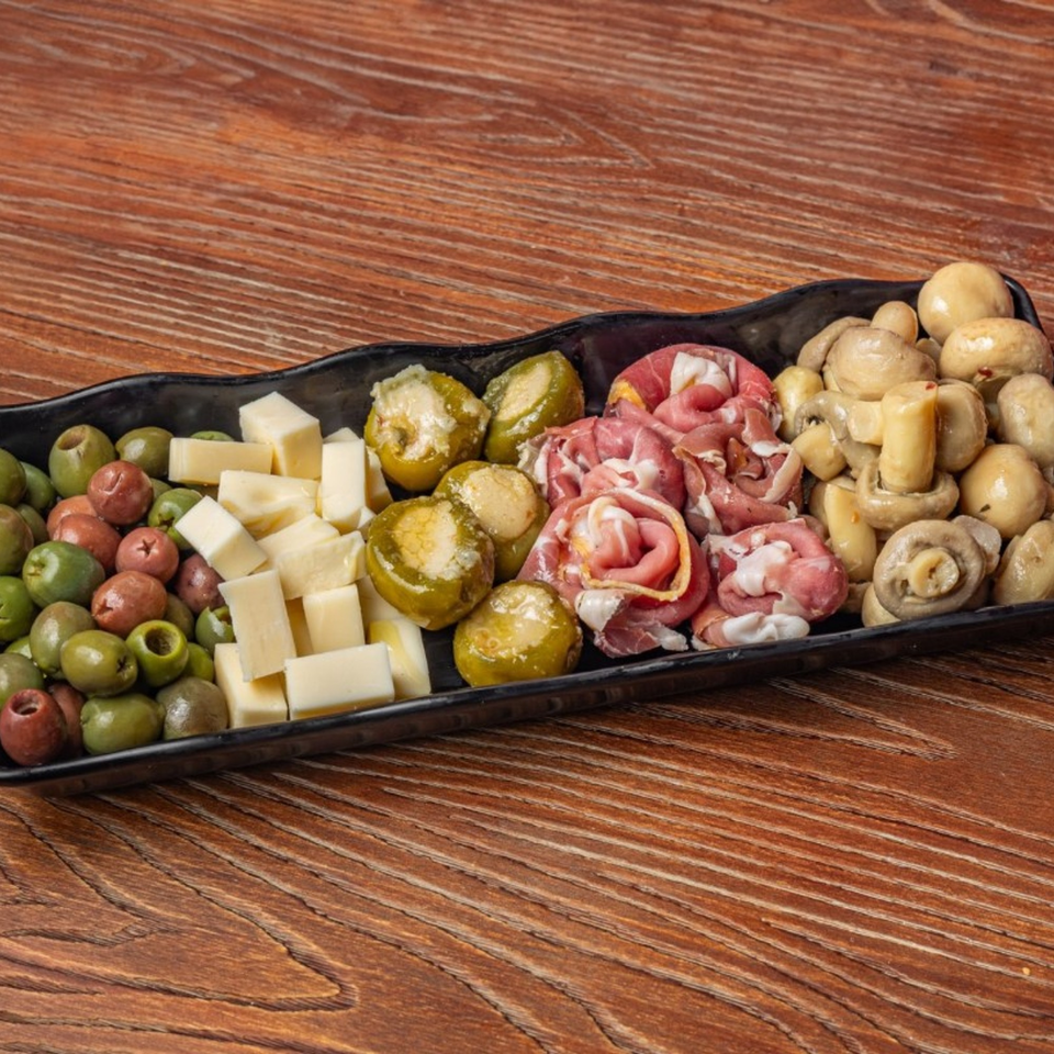 Little Lorenzo's Italian Deli & Catering antipasto platter with olives, cheese, stuffed peppers, prosciutto, and mushrooms.